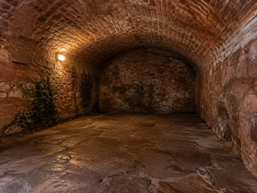 A bare stone chamber under the South Bridge, lit low